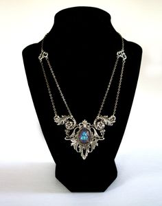 "Gothic Victorian necklace , elven necklace , Art Nouveau statement necklace with crystal , Edwardian necklace , Victorian necklace A unique, Gothic Victorian necklace that adds an elegant statment to any outift!  This Victorian Necklace features an 18 x 13 mm premium cut glass crystal. The crystal color in photos is the color \"Lagoon\" but you can choose your crystal color in the drop down menu (examples of other colors can be seen in the last photo). The crystal is set into gorgeous ornate detailed silver filigree with subtle art nouveau elements. Necklace is finished with antique silver soldered link chain that secures at the back with a lobster clasp. This statement necklace is bold yet very lightweight on the neck.  DETAILS * Chain is 14 inches long - necklace hangs higher on the nec Silver Gothic Necklaces For Fantasy Events, Silver Necklace For Fantasy Events, Fantasy Metal Necklaces For Collectors, Fantasy Metal Pendant Necklace, Handmade Gothic Jewelry For Fantasy Events, Unique Handmade Necklaces For Fantasy Events, Elven Style Metal Jewelry For Gifts, Elven Style Metal Jewelry Gift, Handmade Silver Elven Jewelry