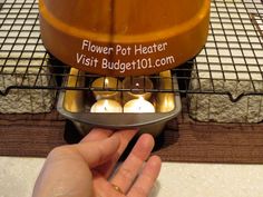 a person holding a metal object in their hand near a pot heater on a rack