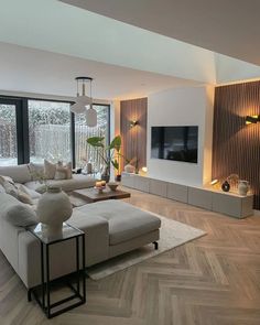 a modern living room with wood flooring and large windows