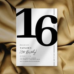 a black and white number sixteen birthday party card on a gold satin background with the word, taylor's late birthday