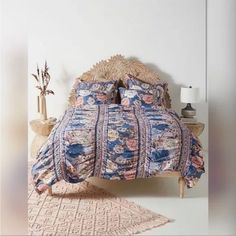 the bed is made up with blue and pink bedspreads, pillows, and blankets