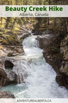 a river running through a forest filled with lots of rocks and water flowing down it's sides