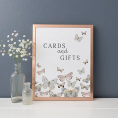 there is a vase with flowers next to a card and gifts sign