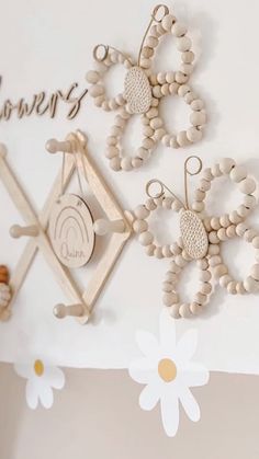 two wooden butterfly decorations hanging on the wall next to a flower and name sign with daisies