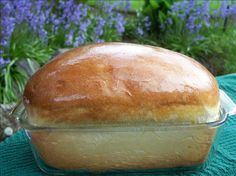 a loaf of bread sitting on top of a green cloth next to blue and purple flowers