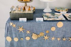 a table topped with cookies and pastries on top of a blue cloth covered table