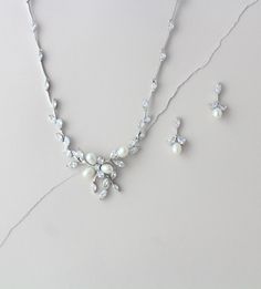 "This decorative floral design made of diamond white freshwater pearls and Cubic Zirconia marquise cut stones is absolutely stunning. Paired with matching silver earrings this bridal set is whimsical and delicate, perfect for your wedding day! Size: 17\" (Necklace Length) 1/4\" (Necklace Width) 1\" (Necklace Drop) 2\" (Earrings Length) 1/4\" (Earrings Width) Also available with backdrop. Please choose style from drop down menu. Matching bracelet: https://www.etsy.com/listing/174590562/bridal-fre Delicate Teardrop Jewelry For Mother Of The Bride, Wedding Fine Jewelry Pearl Drop Necklace, Fine Jewelry Pearl Drop Necklace For Wedding, Elegant Pearl Jewelry Set With Pearl Drop, Elegant Silver Jewelry Set With Pearl Chain, Elegant Pearl Drop Jewelry Set, Delicate Cubic Zirconia Jewelry For Mother Of The Bride, Elegant Cubic Zirconia Jewelry For Mother Of The Bride, Elegant Anniversary Necklaces With Matching Earrings