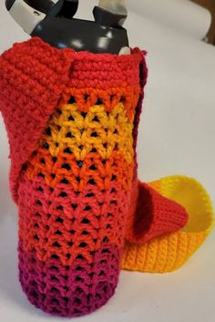 a crocheted cup holder with scissors in it