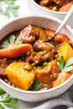 two white bowls filled with stew and vegetables