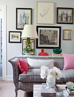 a living room filled with lots of furniture and pictures on the wall above it's coffee table