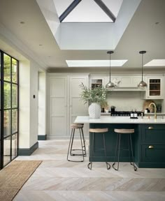 a kitchen with two stools next to an island and skylight above the counter