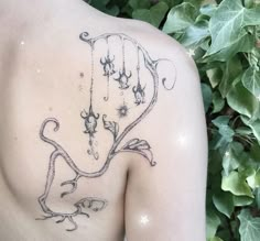 the back of a woman's shoulder with an intricate tattoo design on her chest