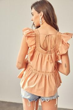 Final Sale - Get it before it's gone! Beautiful weather calls for the Dani Apricot Ruffle Babydoll Top! This flowy, woven top has a square neckline, short ruffle sleeves, and a wide-cut bodice. A relaxed silhouette features a ruffled trim drop seam tier with a ruffle hem. Tassel tie back finishes the look. Pair with your favorite shorts for a cute warm-weather look! DETAILS & CARE Cotton. Machine wash cold. Imported. Summer Smocked Top With Ruffle Hem And Short Sleeves, Spring Tops With Smocked Back And Flutter Sleeve, Flutter Sleeve Tops With Smocked Back For Spring, Spring Smocked Top With Square Neck, Feminine Summer Peasant Top With Ruffles, Chic Summer Smocked Top With Ruffle Sleeves, Flowy Smocked Top With Square Neck For Spring, Spring Flutter Sleeve Blouse With Smocked Back, Spring Square Neck Flowy Smocked Top