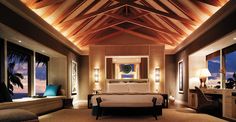 a bedroom with a large bed sitting under a wooden ceiling