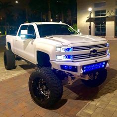 a white truck parked on top of a brick road