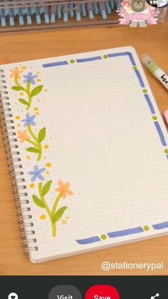 a notepad with flowers on it sitting next to a pen