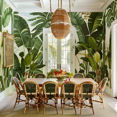 the dining room is decorated with tropical wallpaper