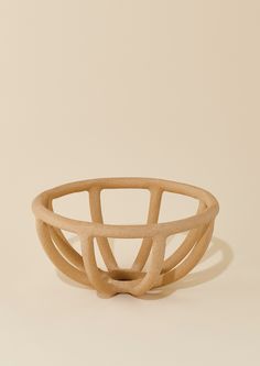 a wooden bowl sitting on top of a white table next to a beige wall and floor