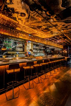 a dimly lit bar with chairs and bars