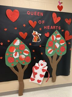 a bulletin board with hearts on it and trees in the background that say queen of hearts