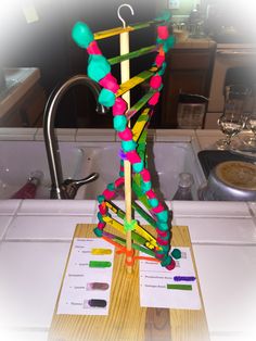 a model of a structure made out of colored pencils sitting on top of a counter