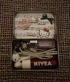 an open tin box with earbuds and headphones in it