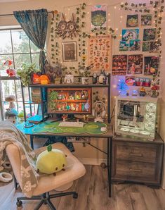 a desk with many pictures on the wall and a stuffed animal sitting in front of it