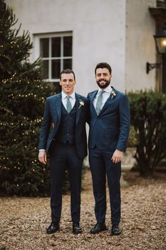 two men in suits standing next to each other