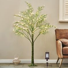 a lighted palm tree next to a chair in a room with a clock on the floor