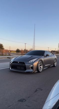 a silver sports car driving down the road