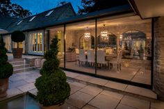 an outdoor dining area with potted plants and large glass doors leading to the patio