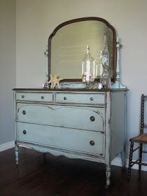 an old dresser with a mirror and starfish on top is shown in this room