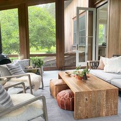 a living room filled with furniture and lots of windows covered in wooden slatted walls