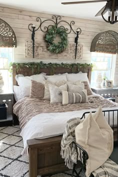 a bed with pillows and blankets on top of it in a bedroom next to a window