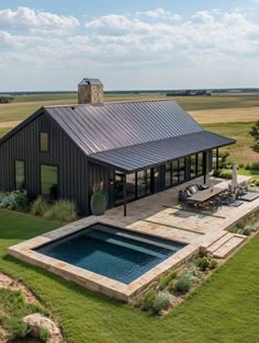 an aerial view of a house with a pool in the foreground and a covered patio