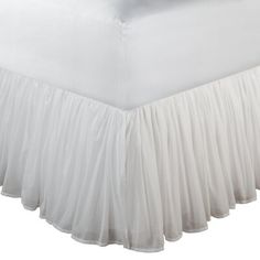 a white bed skirt with pleated edges