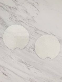 two white circles sitting on top of a marble surface