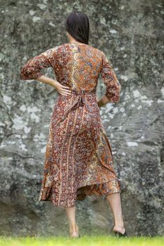 This luxurious Silk/Poly Blend Wrap Dress is the epitome of autumnal color. With its gently flowing ruffled skirt, long length, and bohemian gold embellishments, this dress is perfect for any special occasion. Let its beauty and charm make you shine like the autumn season. Bohemian Fall Dresses With Ruffles, Bohemian Ruffled Dresses For Fall, Bohemian Ruffle Dresses For Fall, Flowy Bohemian Brown Midi Dress, Elegant Flowy Boho Dress With Ruffles, Elegant Long Sleeve Boho Dress For Festival, Brown Silk Dress For Fall, Brown Silk Dresses For Fall, Elegant Fall Maxi Dress With Ruffle Hem