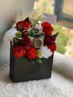 a black box with red and white flowers in it sitting on a furnishing