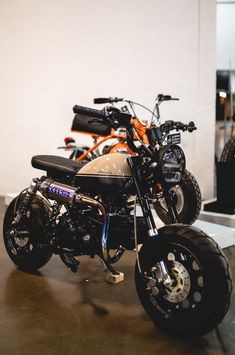 two motorcycles parked next to each other in a room with no one on the bike