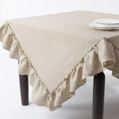 a table with a white plate on it and a tan cloth draped over the top