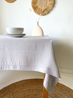 a table with two plates and a vase on it next to some wall hangings