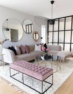 a living room filled with lots of furniture and mirrors on the wall above it's windows