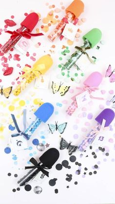 colorful paper butterflies and confetti on a white background with polka dotes in the foreground