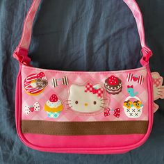 a pink hello kitty purse sitting on top of a bed