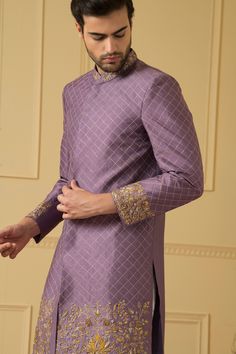 Purple sherwani with mandarin collar, all over checkered pattern zari work and floral pattern gold zardozi hand embroidered borders.
Components: 1
Pattern: Hand Embroidered
Type Of Work: Zardozi and Zari Work
Neckline: Mandarin Collar
Sleeve Type: Full Sleeves
Fabric: Dupion Silk
Color: Purple
Other Details: 
Embroidered collar
Front and side slits
Closure: Front concealed placket
Note: The pant worn by the model is not for sale
Occasion: Groom,Wedding - Aza Fashions Purple Sherwani, Taking Body Measurements, Embroidered Sherwani, Zardosi Work, Sherwani For Men, Men's Ethnic Wear, Embroidered Collars, Dupion Silk, Zari Work