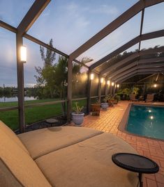 a covered patio area with a pool in the background