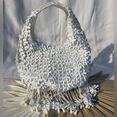 This Darling White Flower Purse Is A Perfect Entrance Into The Spring! Perfect For Your Next Vacation Or Night Out. Delicate And Charming, One Of A Kind, It Is Entirely Covered With Dimensional White Flowers. The Beaded And Flowerette Tassels Take This Design To The Next Level With Its Fun Girly Charm. Its Truly So Well Made And Designed. Spacious Bag Will Hold A Cell Phone, Wallet And Make Up For Touch Ups. Size: From Top Of Strap To Bottom Of Bag 10in Zipper To Bottom Of Bag 5.5in Across 8.5in White Bohemian Handheld Shoulder Bag, White Flower-shaped Shoulder Bag For Everyday Use, White Flower Shoulder Bag For Everyday Use, White Tote Shoulder Bag For Wedding, Summer Wedding Shoulder Bag With Pearl Handle, White Beach Shoulder Bag With Pearl Handle, White Shoulder Bag With Pearl Handle For Beach, White Pouch Bucket Bag For Evening, White Evening Pouch Bucket Bag