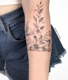 a woman's arm with flowers and leaves tattooed on the left side of her body