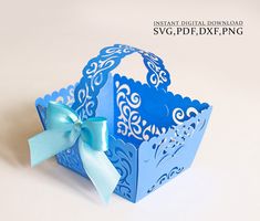 a blue paper box with a bow on the front and side, sitting on a white surface